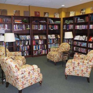 A cozy reading area in a library with comfortable armchairs and bookshelves filled with books.