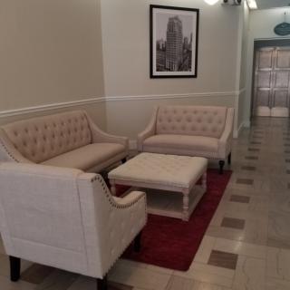 A cozy lobby area featuring two sofas, a coffee table, and a framed picture on the wall.