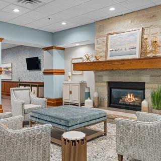 A modern lounge area featuring a cozy fireplace, comfortable seating, and stylish decor.