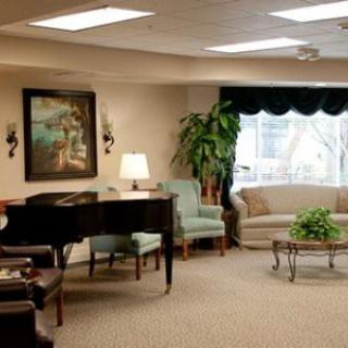 A cozy living room featuring a grand piano, comfortable seating, and tasteful decor.