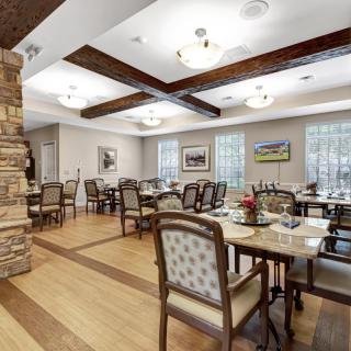 A well-lit dining room with elegant furniture and wooden floors.