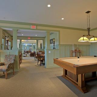 A spacious game room featuring a pool table and elegant lighting.