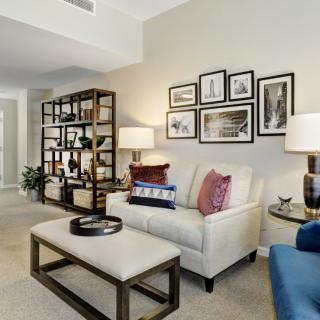 A cozy and stylish living room featuring a comfortable sofa, bookshelves, and elegant decor accents.