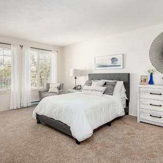 A modern, cozy bedroom with a white theme and natural light.