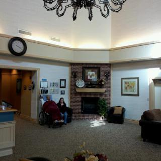 A cozy lobby featuring comfortable seating, a decorative fireplace, and elegant lighting.