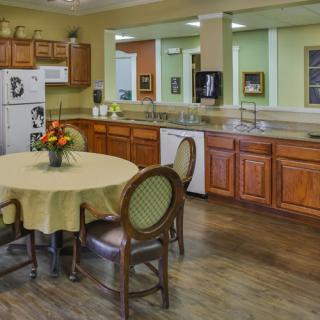 A spacious kitchen featuring wooden cabinets and a round dining table with chairs.