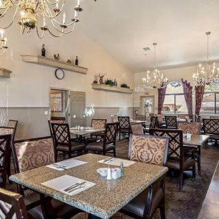 Elegant dining area with chandeliers and neatly arranged tables and chairs.