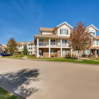 A suburban apartment complex on a sunny day with trees lining the street.