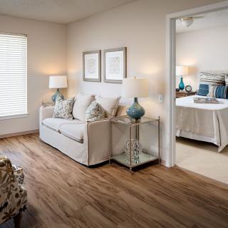 A cozy living room leads into a well-decorated bedroom, featuring comfortable furniture and stylish decor.