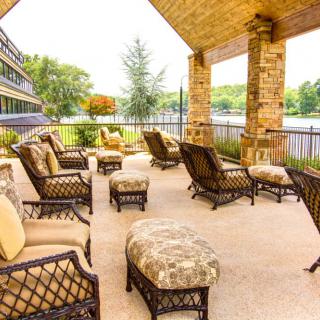 Cozy outdoor patio with comfortable seating and a lake view.