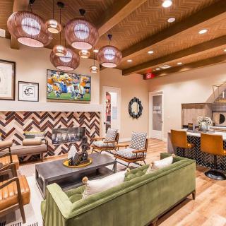 A stylish living room featuring modern decor with a mix of wood textures, colorful artwork, and cozy seating arrangements.
