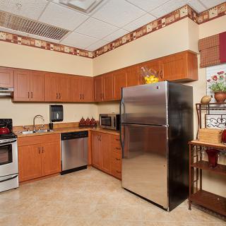 A modern kitchen with wooden cabinets, stainless steel appliances, and a cozy design.