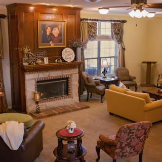 A cozy living room with a fireplace, sofas, and elegant decor.