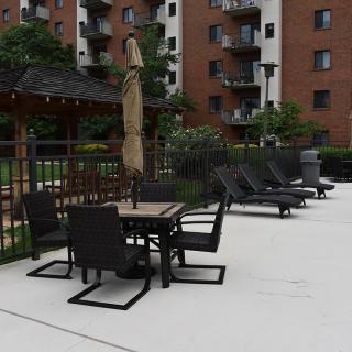 Outdoor patio furniture near an apartment building pool area.