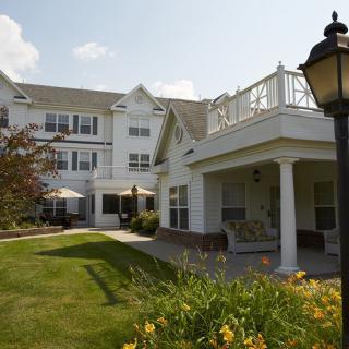 A picturesque view of a residential building with a well-maintained lawn and vibrant landscaping.