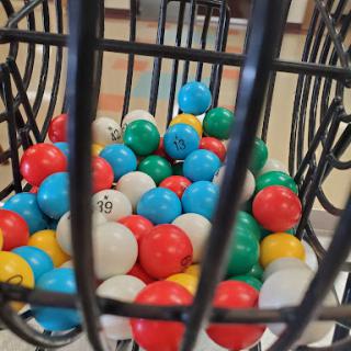 A vibrant assortment of bingo balls inside a metal cage, ready for the next game.