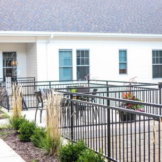 A modern outdoor patio area featuring seating and decorative plants.