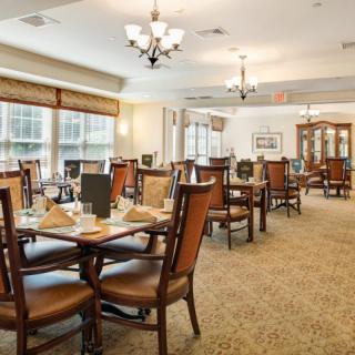 A spacious and elegantly decorated dining room with multiple tables set for dining.