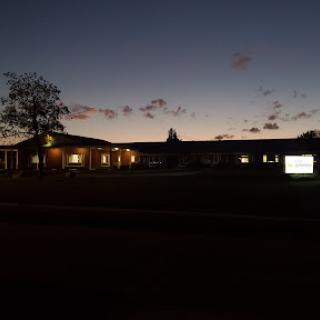 A serene view of a building illuminated at dusk.