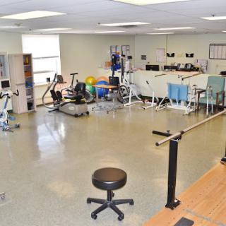 A well-equipped physical therapy gym featuring various exercise machines and rehabilitation tools.