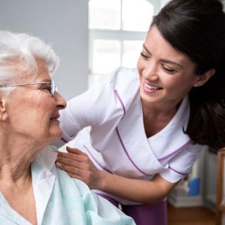 A nurse provides care and support to an elderly woman, creating a warm and friendly atmosphere.