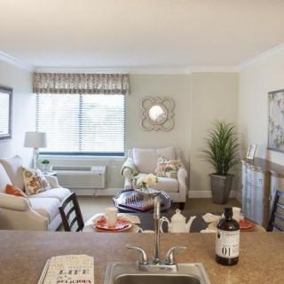 A cozy and well-decorated living room in an apartment with comfortable furniture and a large window.