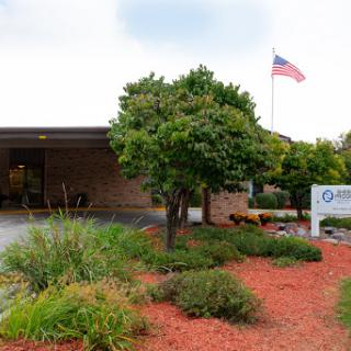 A well-maintained building with landscaping and an American flag.