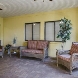 A cozy indoor seating area with wicker furniture and a potted plant.