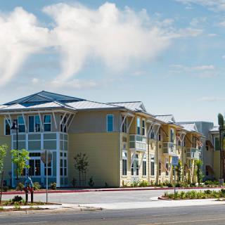 A modern residential building with a stylish architectural design under a clear, sunny sky.
