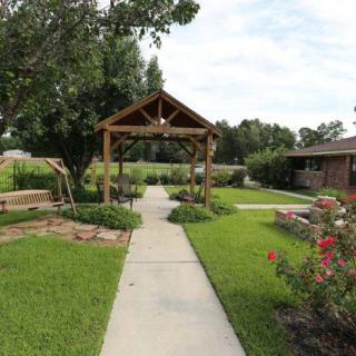 A peaceful garden with a wooden gazebo and well-maintained pathway.