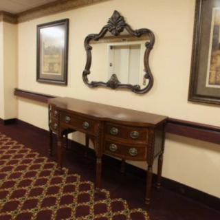 A hallway with a decorative wooden table and an ornate mirror.