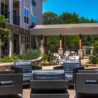 A modern outdoor seating area with rattan chairs in an apartment complex.