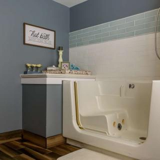 A modern bathroom featuring a walk-in tub with stylish blue and white tiles, providing accessibility and comfort.