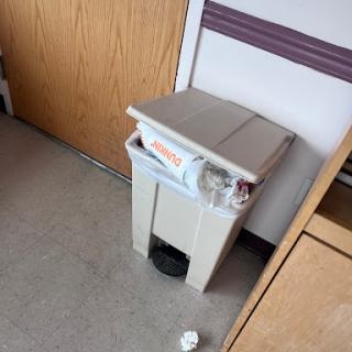 A trash can located in a hospital room, indicating a neat and organized environment.