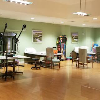 A spacious and well-lit office workspace with modern furniture and a calming green color scheme.