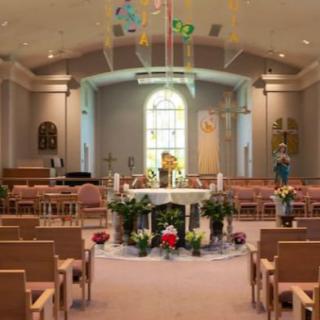 A beautifully decorated church interior featuring an altar surrounded by seating and floral arrangements.