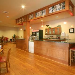 A cozy restaurant interior featuring a wooden bar and dining area.