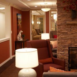 A cozy living room interior with comfortable seating, warm lighting, and a stone accent wall.