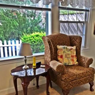 Cozy reading nook by the window with an armchair and side table.