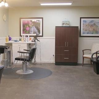 An interior view of a hair salon featuring styling chairs, mirrors, and hair care products.
