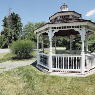 A charming gazebo situated in a lush green park, perfect for relaxation and enjoying nature.