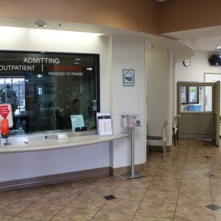 A hospital reception area with an admitting counter and a waiting room.