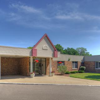 A welcoming entrance to a residential building with well-maintained landscaping.