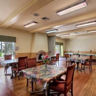 A well-lit dining area with decorated tables and wooden floors.