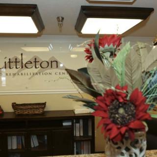 A reception area with floral decoration and office signage in the background.