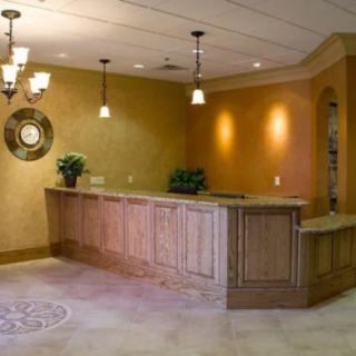 A warmly-lit hotel reception area featuring a wooden desk and decorative elements.