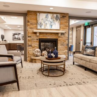 A modern and cozy living room with a stone fireplace and comfortable seating arrangements.