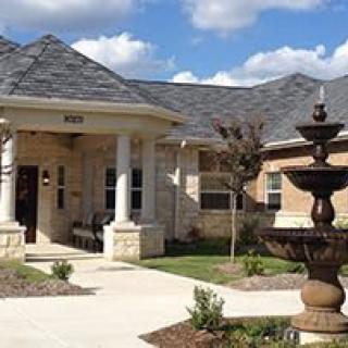 A well-maintained residential house with a fountain at the entrance.