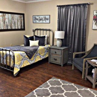 Cozy bedroom with a metal bed frame, patterned bedding, and complementing decor.