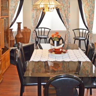 A cozy dining room with a stylish table and chairs, adorned with decorative vases and elegant curtains.